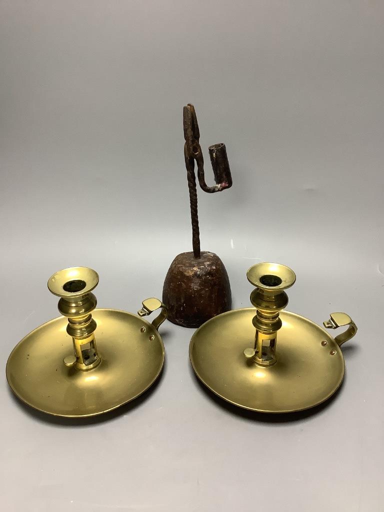 A pair of Regency brass ejector chambersticks (lacking snuffers) and an early 19th century wrought iron rushlight holder